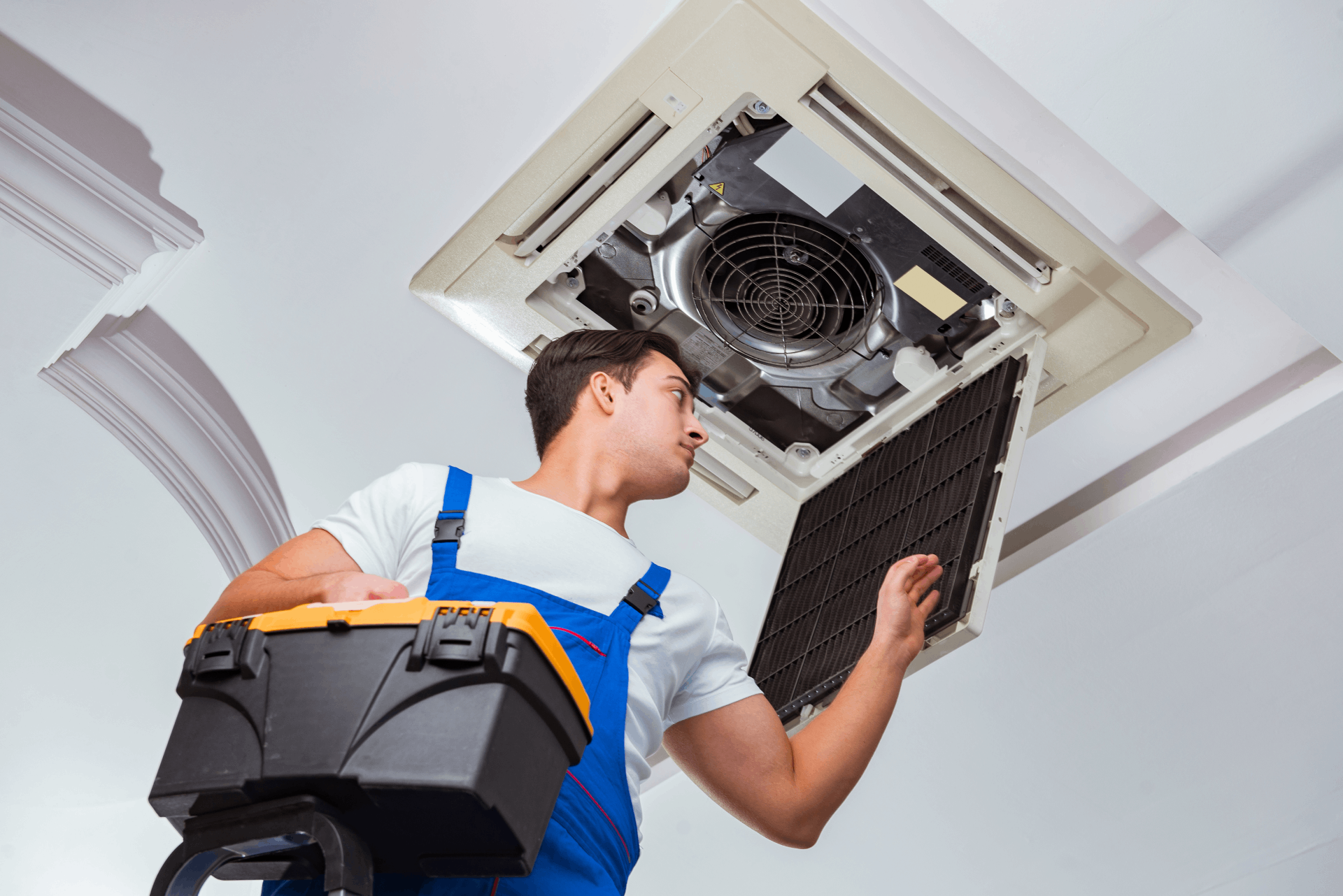 Técnico revisando unidad de aire acondicionado en una sala